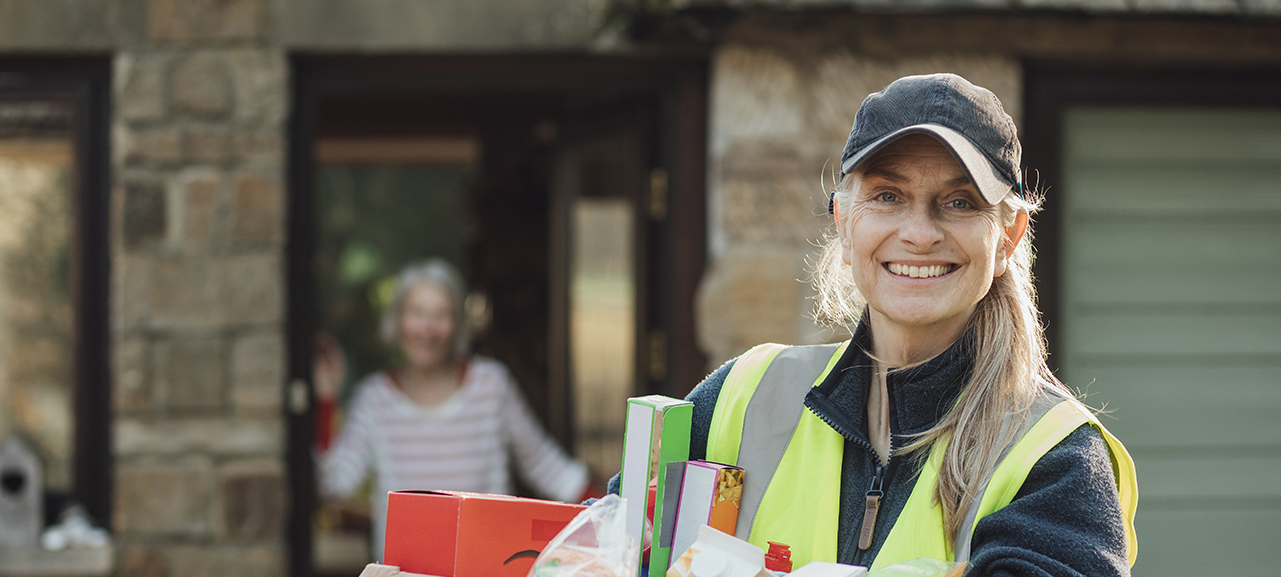 Image of volunteer holding a box of groceries